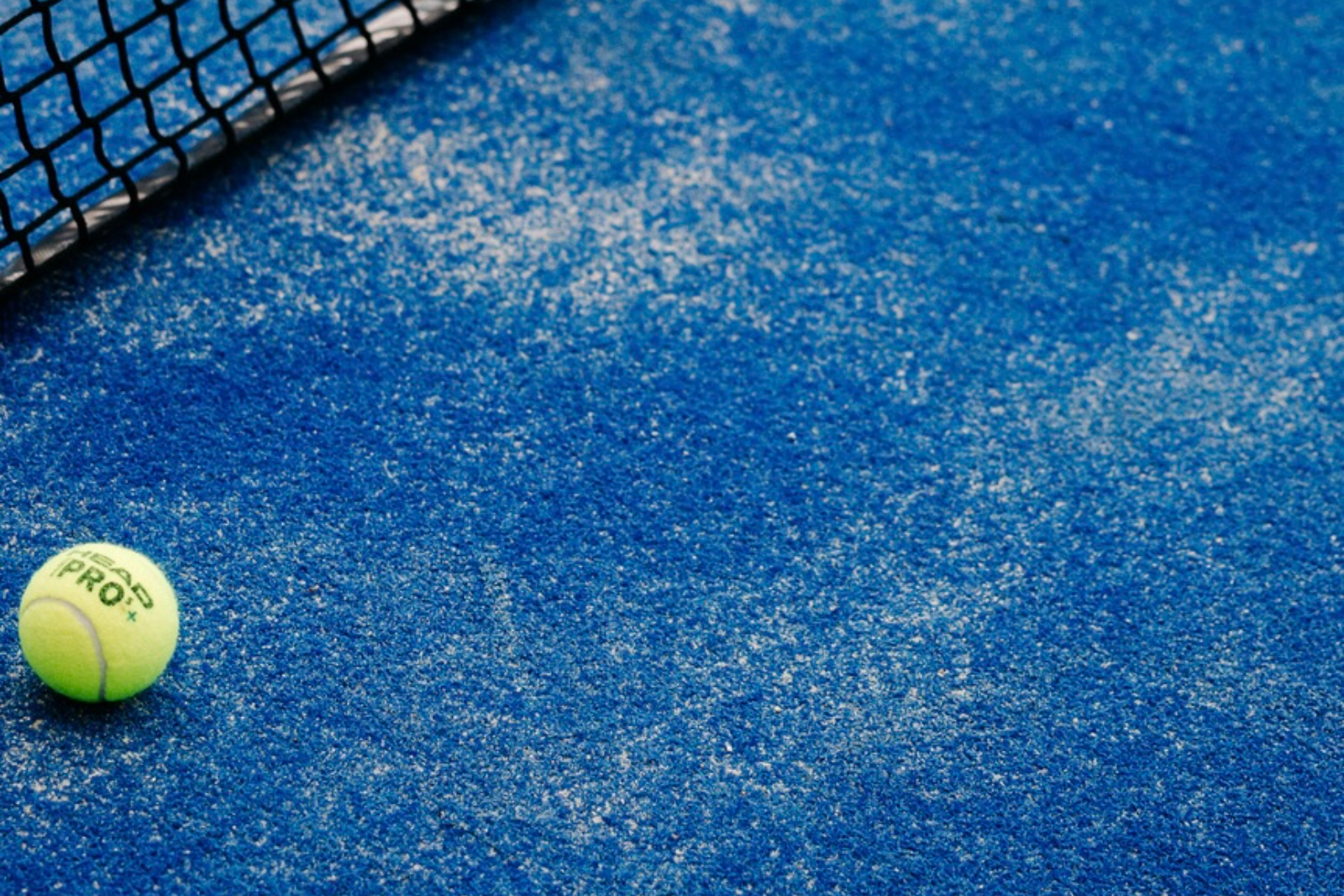 Blauer Padel-Kunstrasen mit Netz und Ball